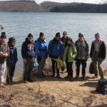 Members of MCM standing in front of a lake