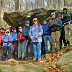 A group of MCM members standing in front of large rocks