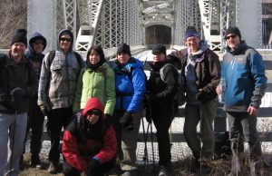 A group of MCM members standing in front of a bridge